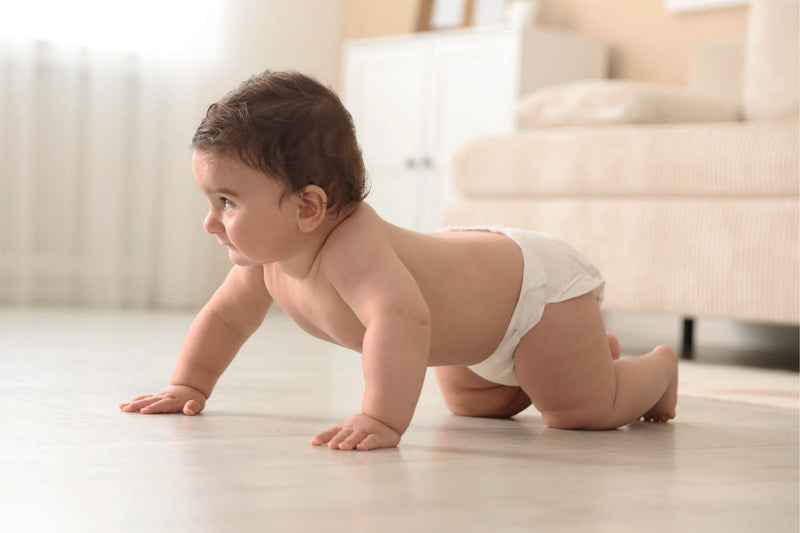 Baby crawling on freshly cleaned floor using non-toxic floor cleaner in a safe home environment